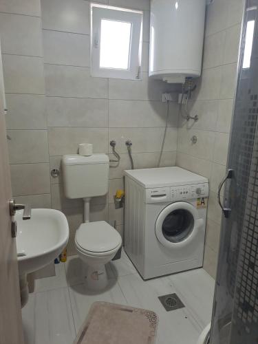 a bathroom with a toilet a sink and a washing machine at Stan Marina in Pale