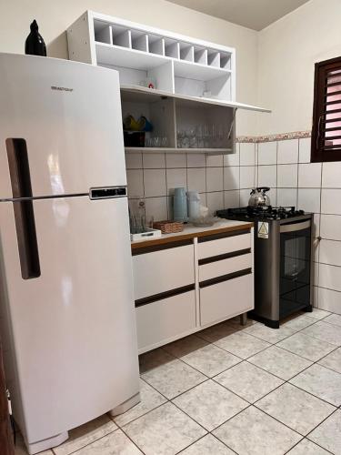 a kitchen with a refrigerator and a stove at CASA MAR DOCE LAR GOSTOSO - A 150M DA PRAIA in São Miguel do Gostoso