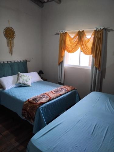 a bedroom with two beds and a window at Casa Natturvibe - Praia do Rosa in Praia do Rosa