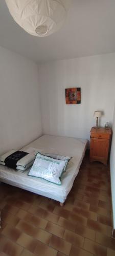 Una cama con dos almohadas encima en una habitación. en Appartement Cosi Place Martinique, en Le Barcarès