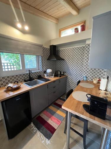 a kitchen with a sink and a wooden table at Nerita's country houses in Néa Tírins