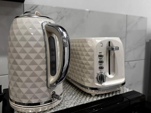 a toaster and coffee maker sitting on a counter at Modern One Bedroom Flat in Twickenham for Business Travelers in Hanworth