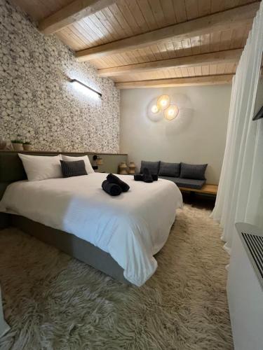 a bedroom with a large white bed and a couch at Nerita's country houses in Néa Tírins