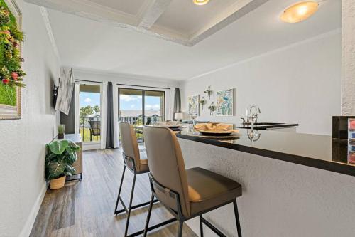 a kitchen with a counter with chairs and a table at Waterfront Balcony Pool AC Smart TV in Tampa