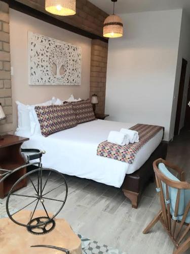 a bedroom with a bed and a desk and a chair at Hotel El Giro in Villa de Leyva