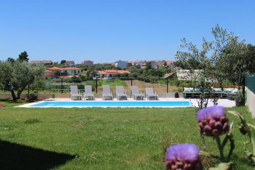 a view of a swimming pool in a yard with purple flowers at As Tílias Homely 46 in Carvalhal