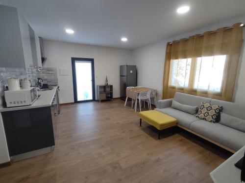 a living room with a couch and a kitchen at As Tílias Homely 46 in Carvalhal