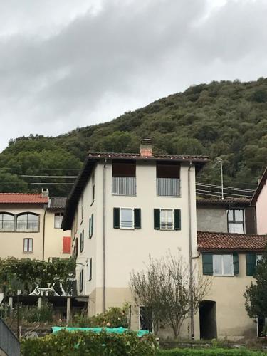 a white building with a mountain in the background at Casa Galett in Novaggio