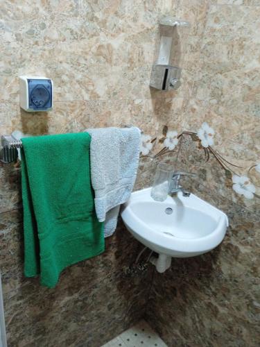 a bathroom with a sink and green towels at Уютный дом in Gyumri