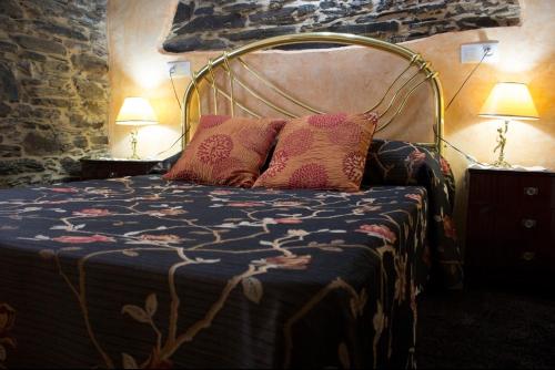 a bed with two pillows on it in a room at Casa Mameleiro e Casa Kintal in A Pontenova