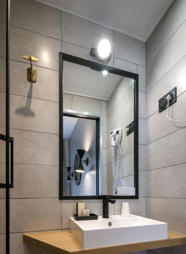 a bathroom with a sink and a mirror at Hôtel Bristol Union Intra Muros in Saint Malo