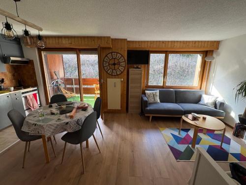 a living room with a table and a couch at Petit havre de paix! in Les Collons