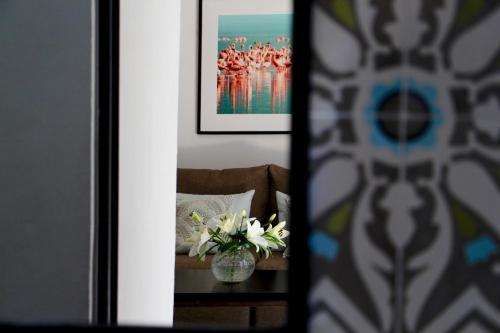 a room with a table with a vase of flowers at The Diplomat Boutique Hotel in Mérida