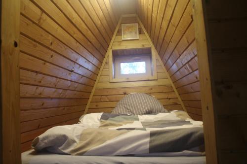 a bed in a tree house with a window at Chata na Orave so saunou a kúpacou kaďou in Námestovo