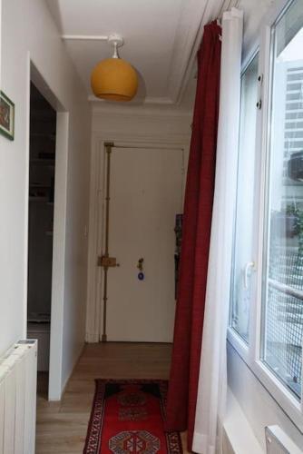 un couloir avec un rideau rouge et une fenêtre dans l'établissement Cosy Flat 30m2 Paris Centre, à Paris