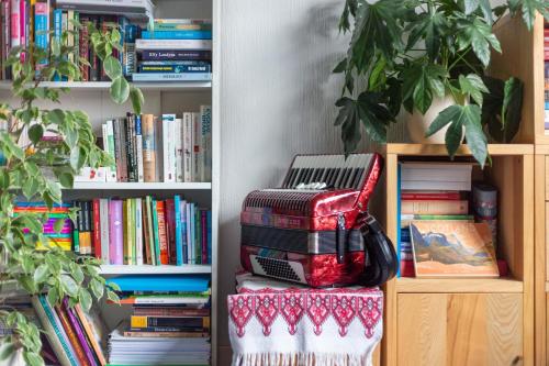 a stack of books in front of a book shelf at Bright & Spacious Double Room with Garden View- Close to Airport & City Centre in Edinburgh