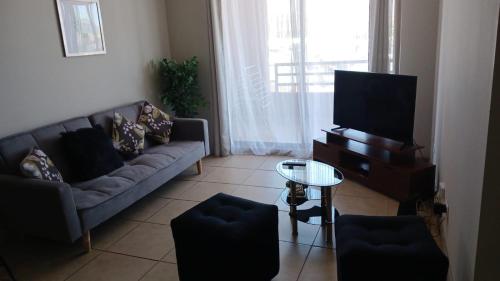 a living room with a couch and a tv at Los Andes familiar y tranquilo in Los Andes