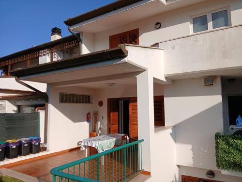 a white house with a green railing on a balcony at La casa di ale in Latina