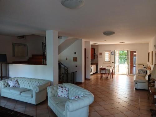 a living room with two couches and a kitchen at La casa di ale in Latina