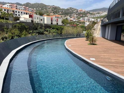 a swimming pool next to a building at Varandas do Atlântico in Câmara de Lobos