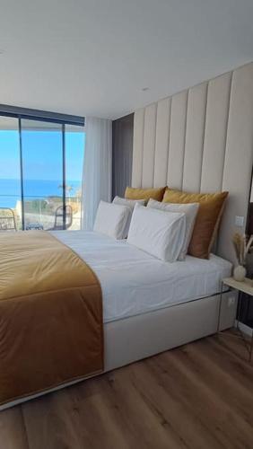a bedroom with a large bed with a view of the ocean at Varandas do Atlântico in Câmara de Lobos