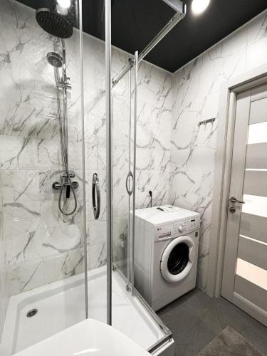 a bathroom with a washing machine and a washer at Світлі апартаменти в самому Центрі біля Корпусного парку - Мережа HELEN in Poltava
