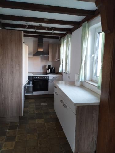 a kitchen with white cabinets and a stove at Ferienwohnung Wechterswinkel in Bastheim