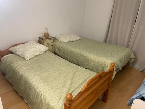 - une chambre avec 2 lits et une table de chevet dans l'établissement Belle maison à proximité de Château de Versailles avec parking, à Plaisir