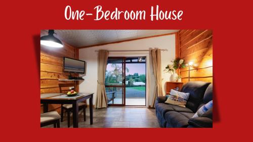 a living room with a couch and a table at Swiss-Kiwi Cottage and Retreat, B&B in Tauranga