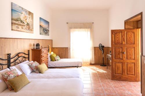 a bedroom with two beds and a dresser at Casa Seña Catalina, antigua casa típica canaria in La Oliva