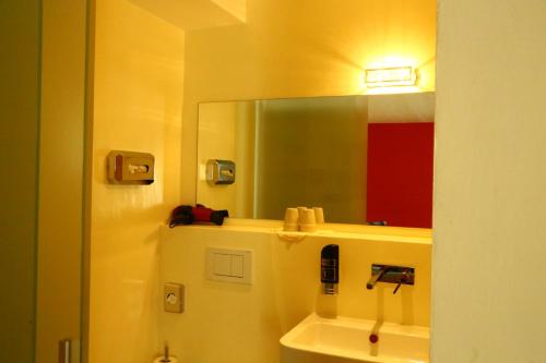 a bathroom with a mirror and a sink at Hotel Bellavista Ftan in Ftan