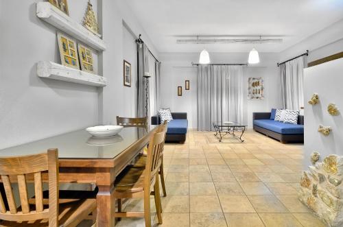 comedor y sala de estar con mesa y sillas en Niriides Luxury Apartments en Sivota
