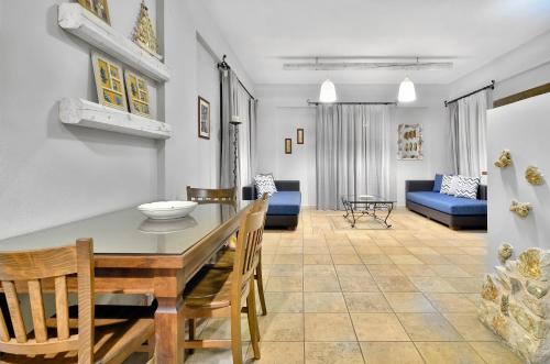 a dining room and living room with a table and chairs at Niriides Luxury Apartments in Syvota