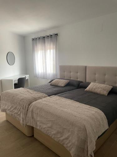 a bedroom with a large bed and a desk at El Rincón del Mirador in Carboneras de Guadazaón