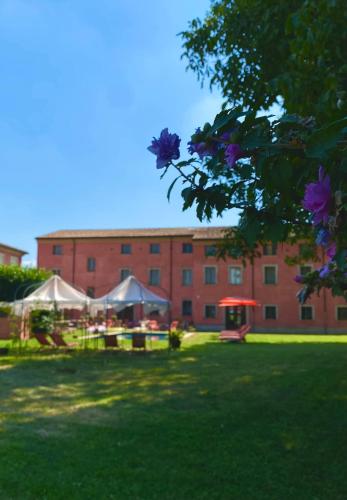 a large brick building with a green lawn in front of it at Hotel Villa Montanarini in Villarotta