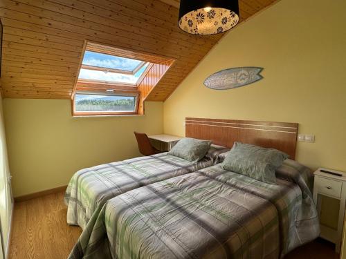 a bedroom with two beds and a window at Las Catedrales ático Oceano VI in Barreiros