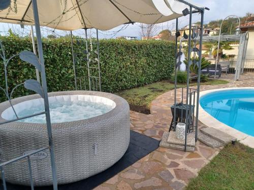 a hot tub with an umbrella next to a pool at Boville Family House in Boville Ernica