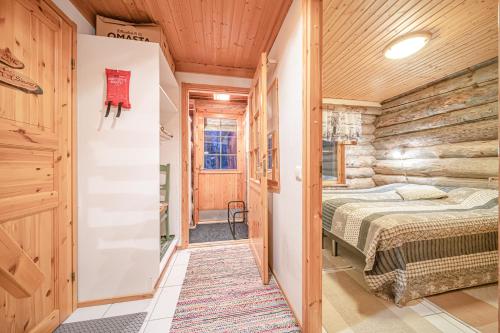 a bedroom in a log cabin with a bed and a hallway at Kiiruna by Aavalevi Holidays, Levi Center in Levi