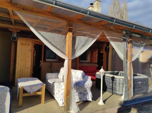 a patio with a tent and a couch and a table at Szofi Vendégház in Kereki