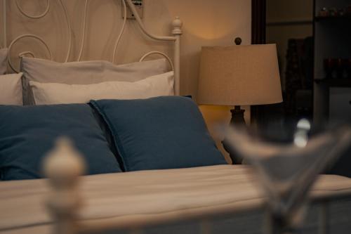 a bedroom with a bed with blue pillows and a lamp at Elegant Boho Style Studio Haven in Abu Dhabi