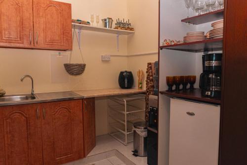 a kitchen with a sink and a refrigerator at Elegant Boho Style Studio Haven in Abu Dhabi
