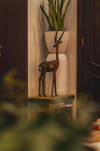 a statue of a deer on a table next to a vase at Elegant Boho Style Studio Haven in Abu Dhabi