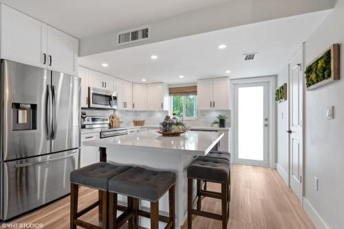 a kitchen with a refrigerator and two bar stools at Keys Relaxing Getaway-Kawama K5 in Key Largo