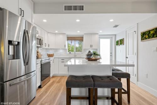 a kitchen with white cabinets and a large refrigerator at Keys Relaxing Getaway-Kawama K5 in Key Largo