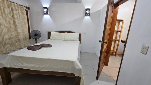 a small bedroom with a bed and two lights at Hotel Restaurante Los Cocos in Santa Cruz