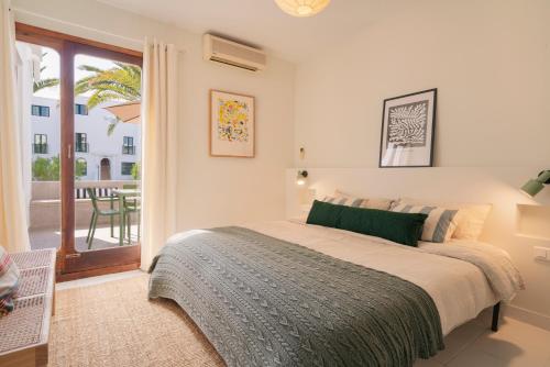 een witte slaapkamer met een bed en een balkon bij Lanzarote Beach Apartments, CASA BRUNA in Costa Teguise