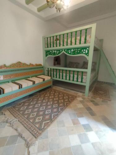 a room with two bunk beds and a rug at Dar lella habiba in Kairouan