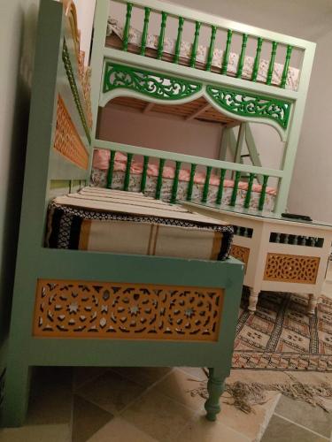 a green and white bunk bed with a bench at Dar lella habiba in Kairouan