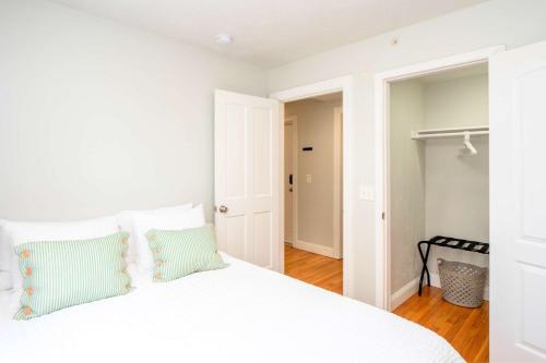 a bedroom with a white bed with blue pillows at Jennifer's College Hill Apartment Close to Everything in Providence
