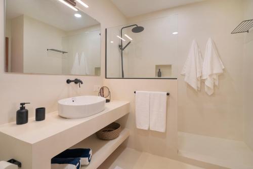 een witte badkamer met een wastafel en een spiegel bij Lanzarote Beach Apartments, CASA BRUNA in Costa Teguise